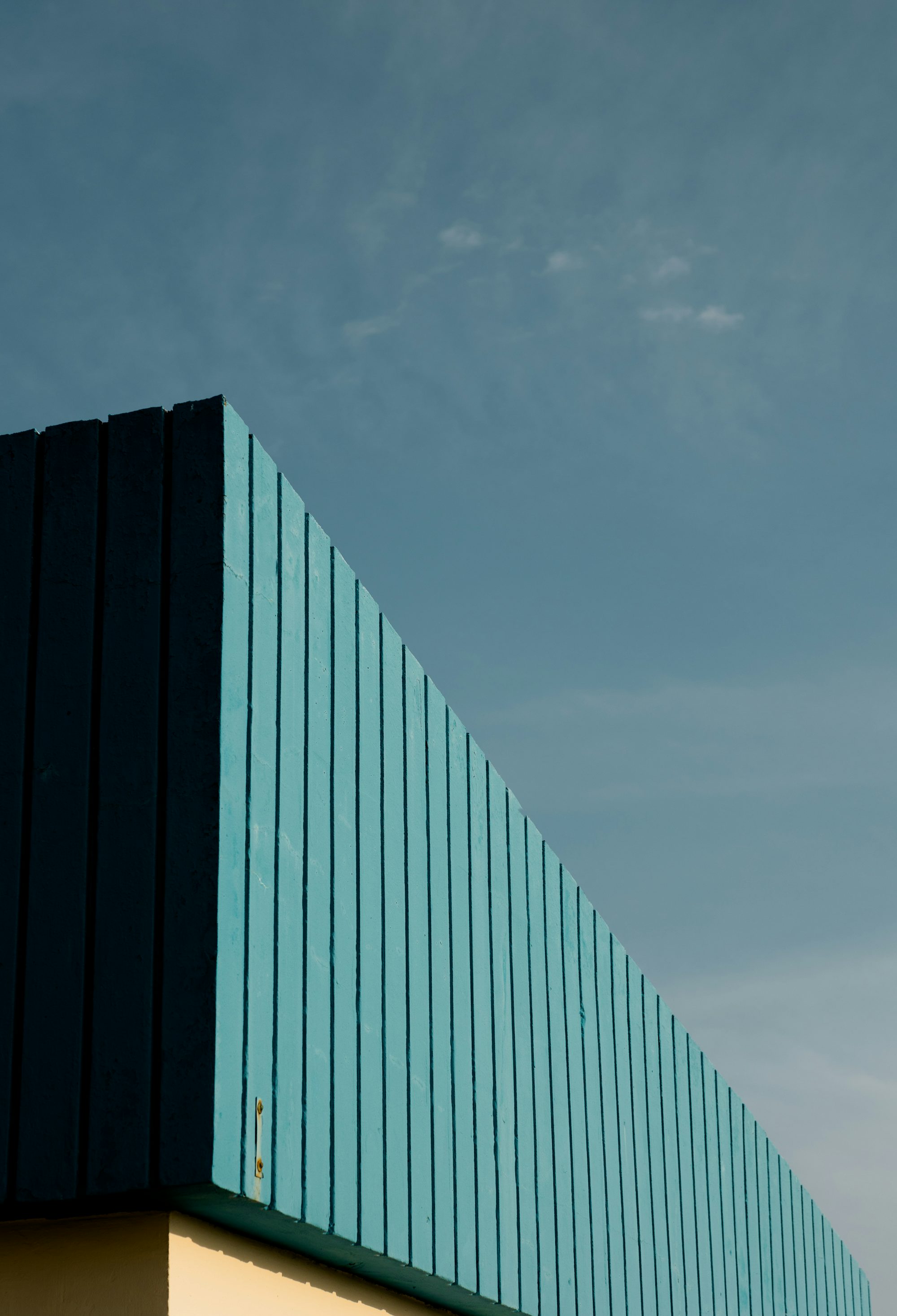 an airplane flying over a building with a sky background