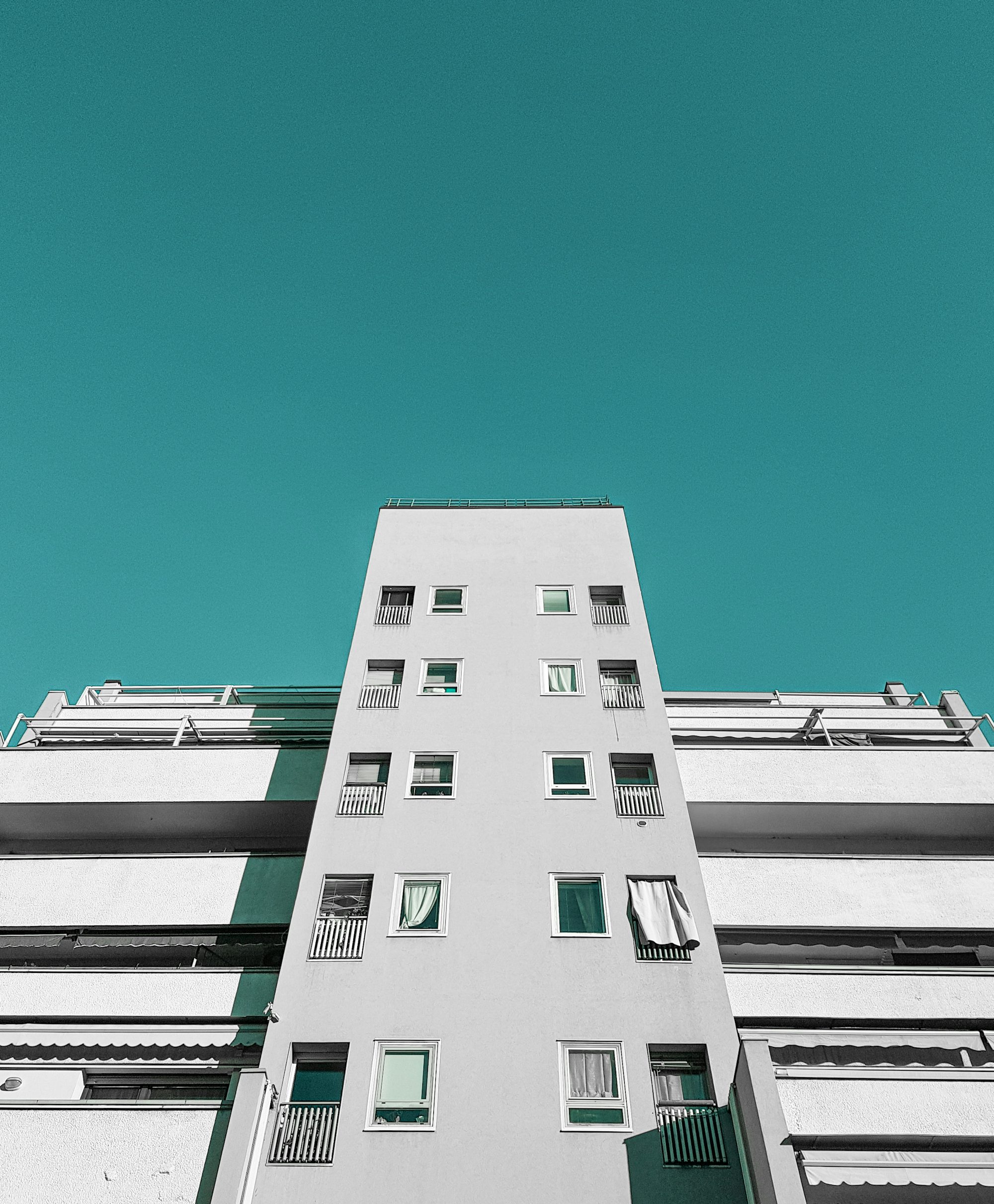 a tall white building with balconies and windows