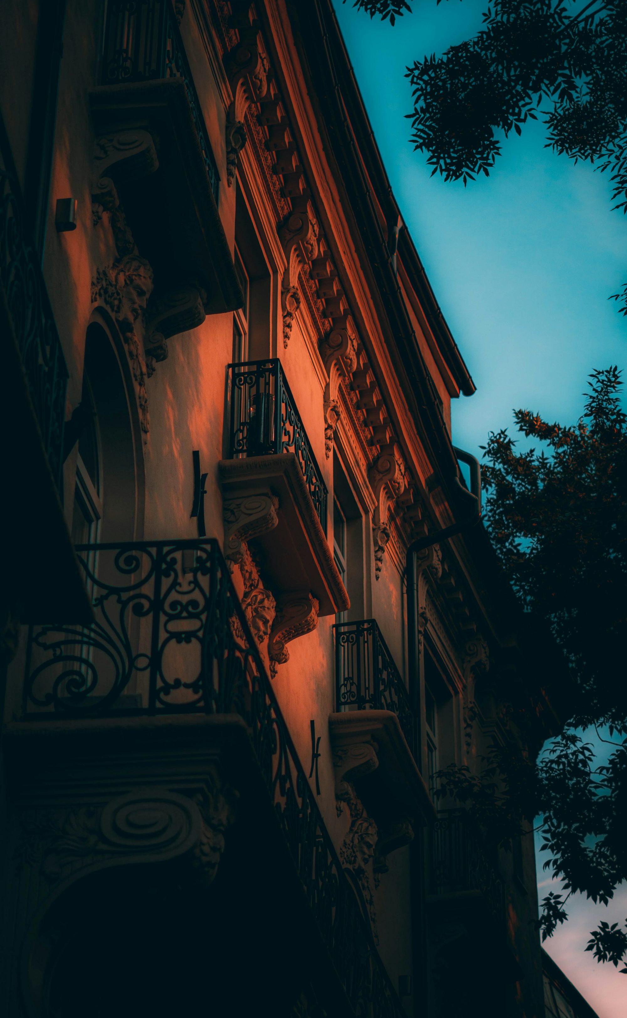 a building with balconies and trees in the background