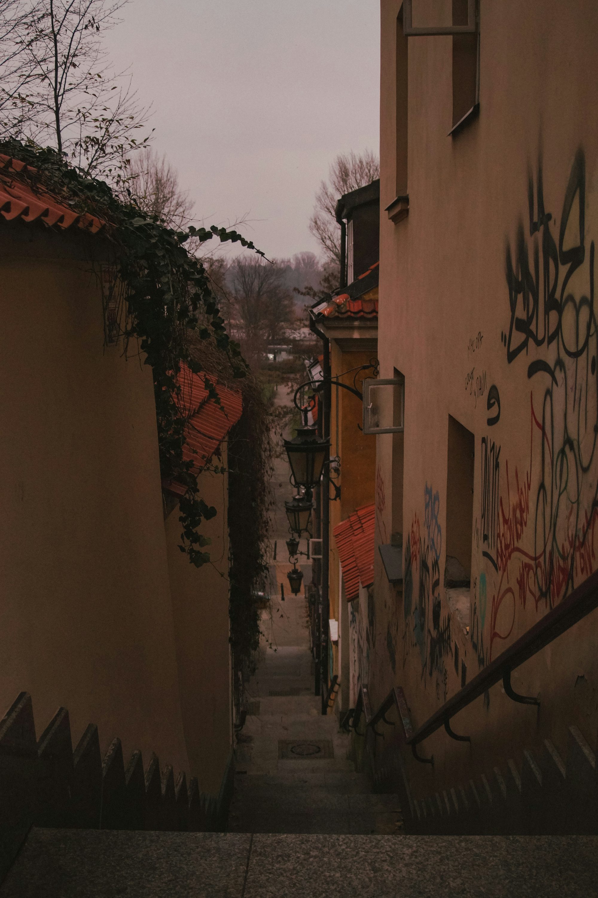 a narrow alley with graffiti on the walls