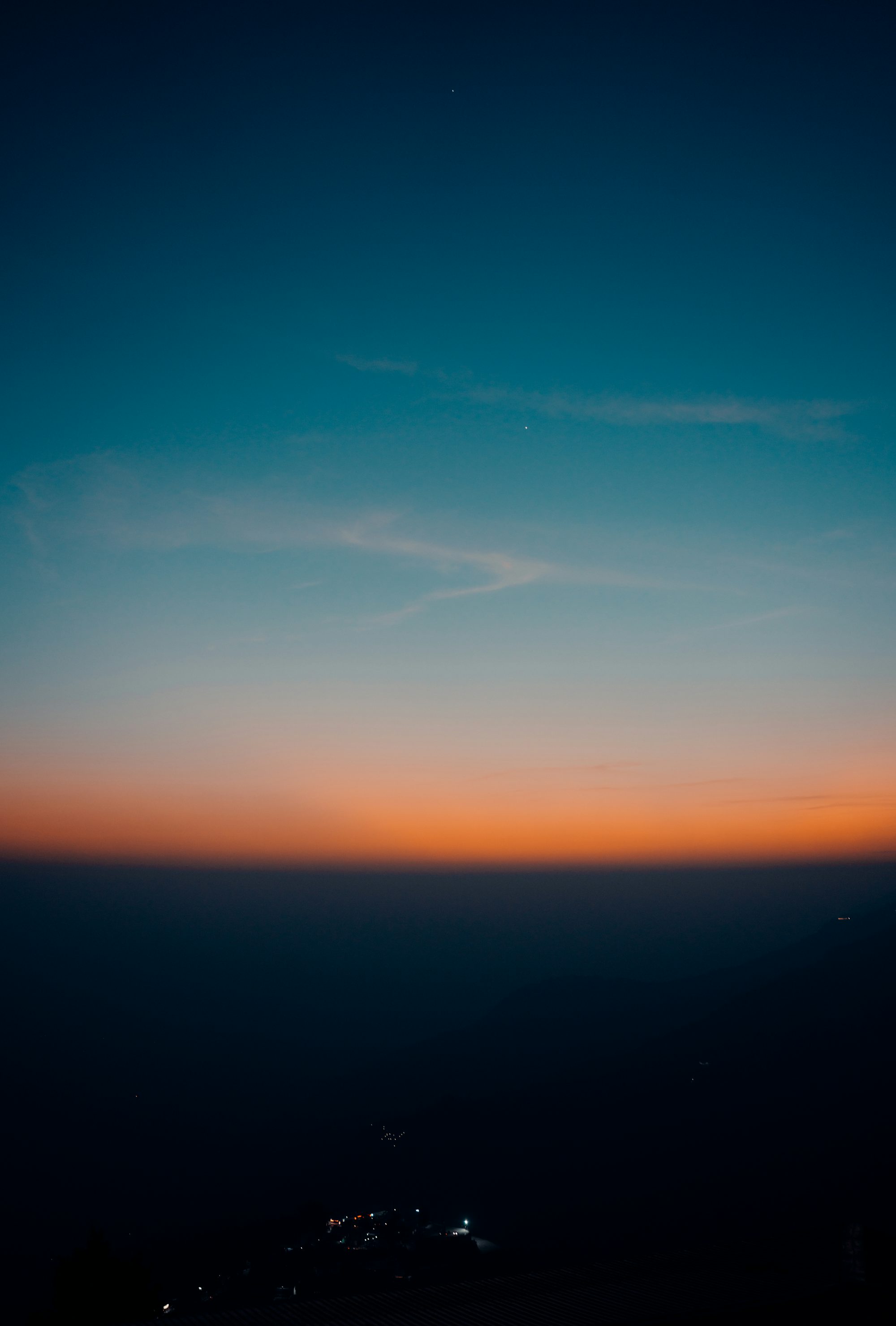 a view of the sky at night from the top of a hill