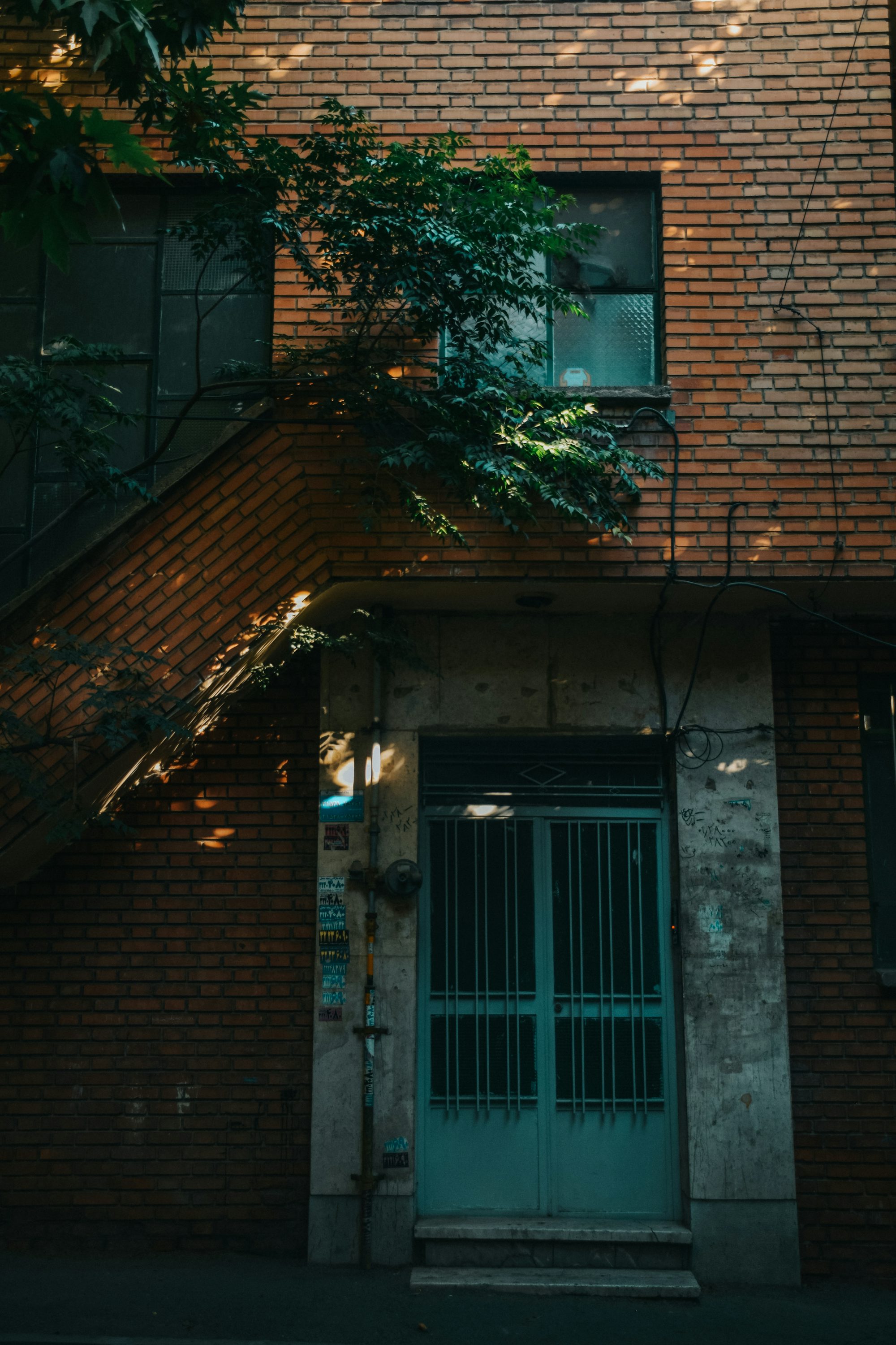 a tall brick building with a green door