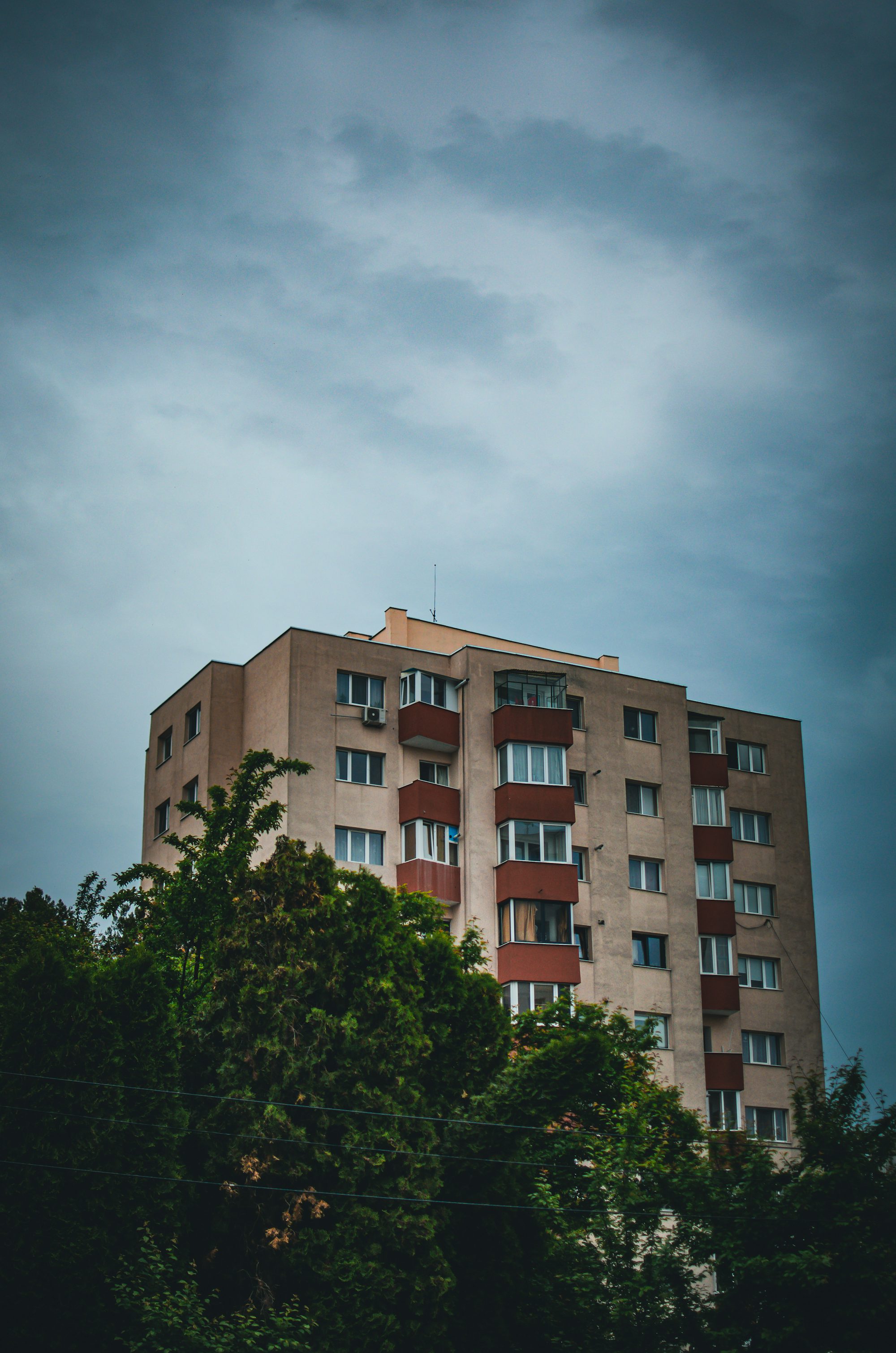 a tall building with lots of windows next to trees