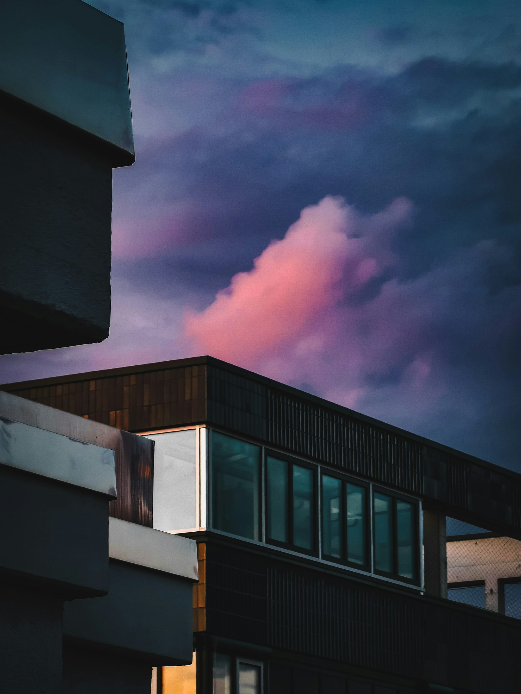 a building with a pink cloud in the sky