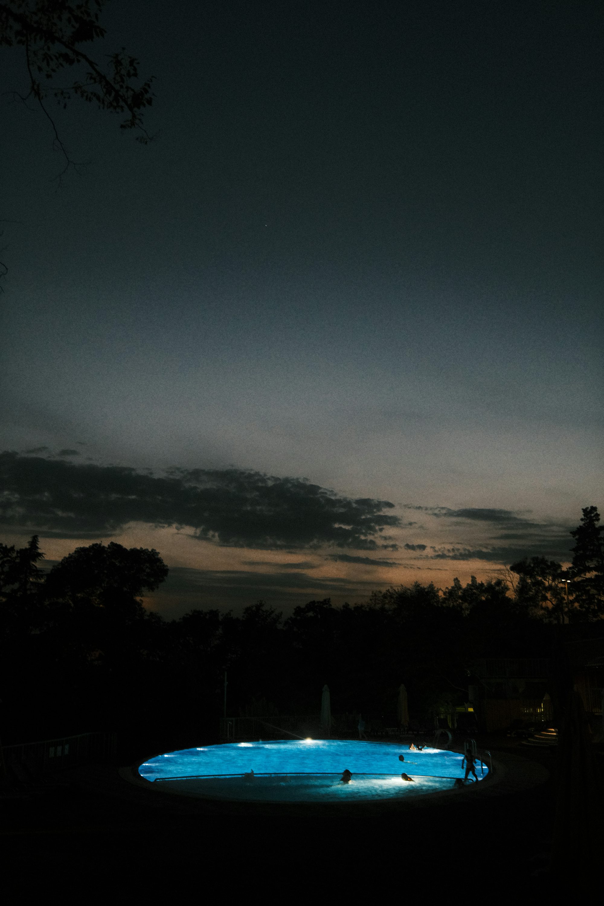 a lit up fountain in a park at night