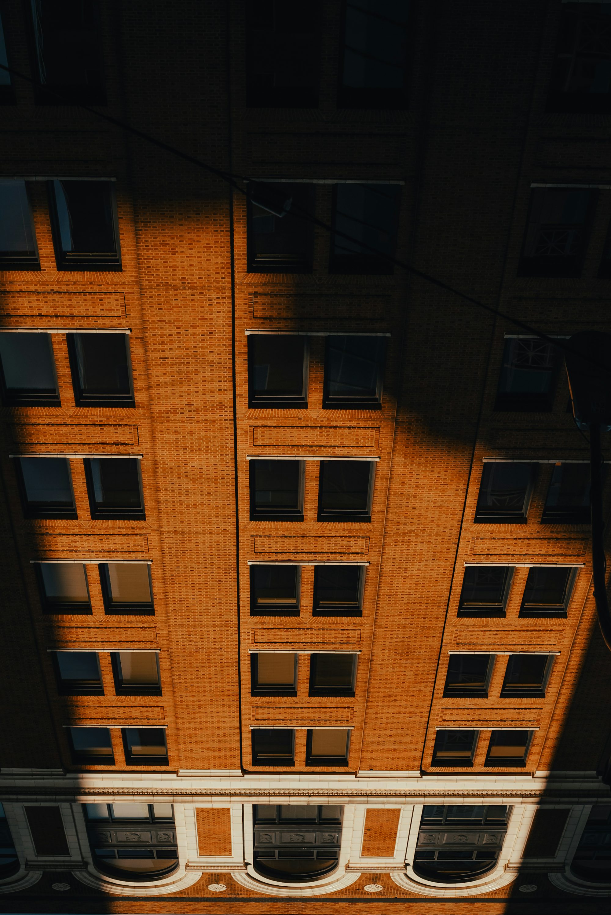 a tall building with windows and a clock on the side of it