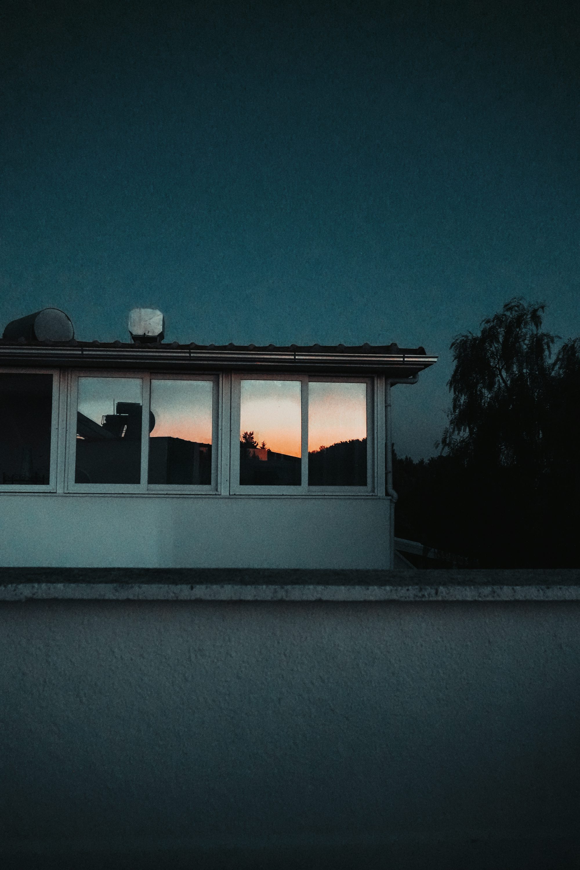 A house with a roof and windows at night