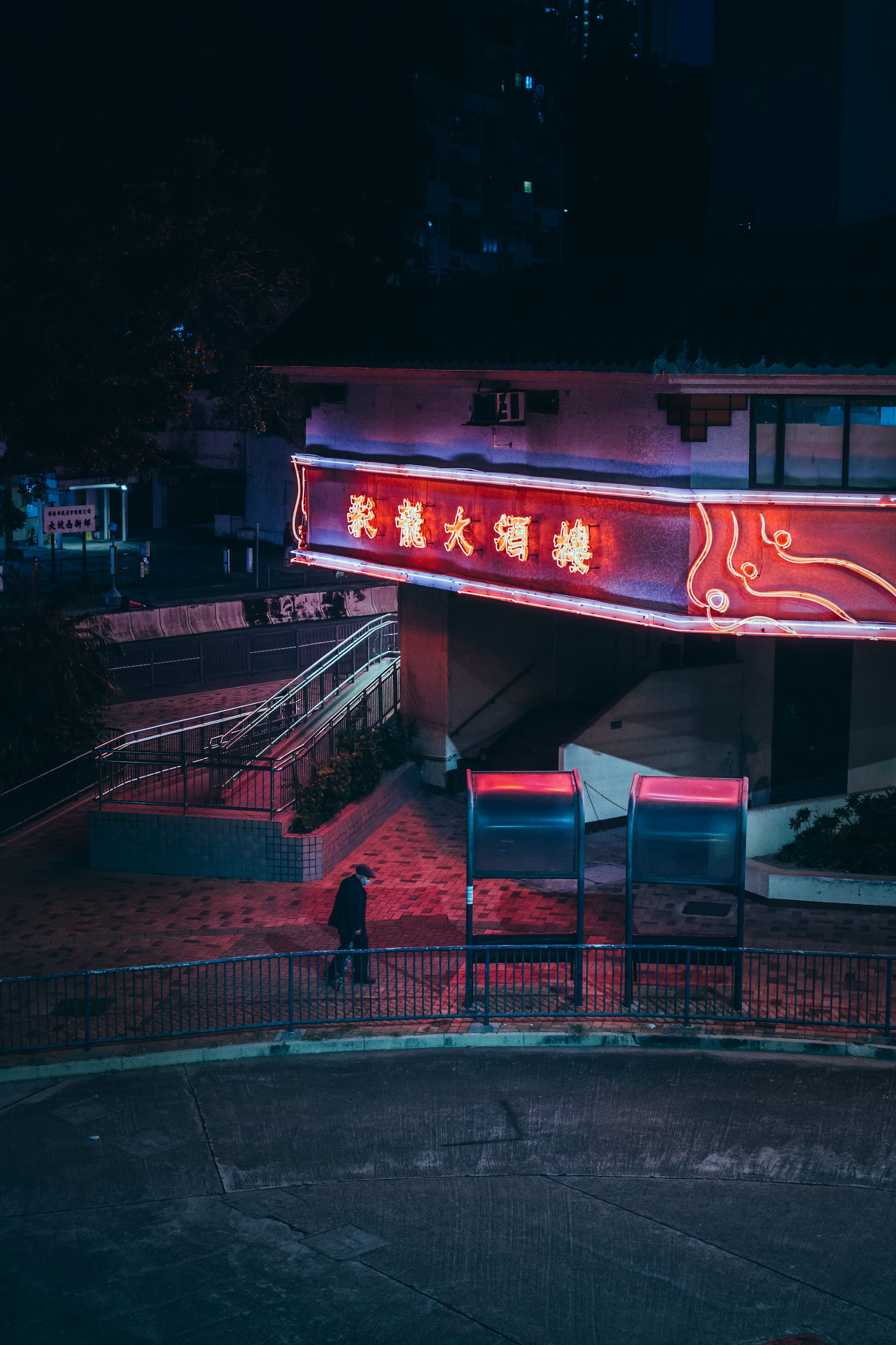 A red neon sign that is on the side of a building