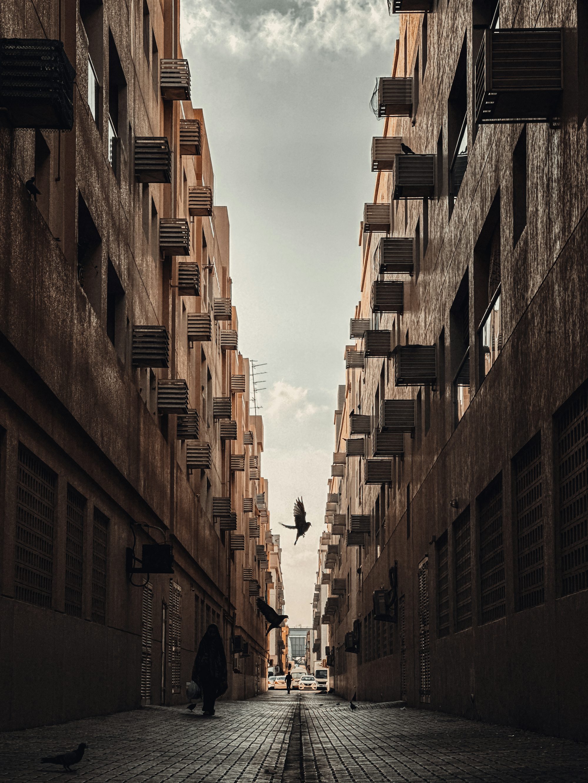A person walking down a street between two buildings