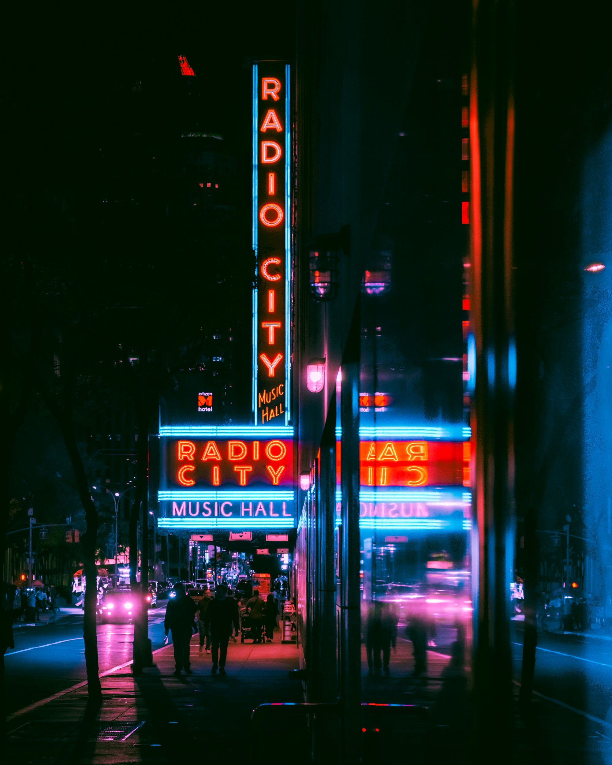 A city street at night with a radio city sign
