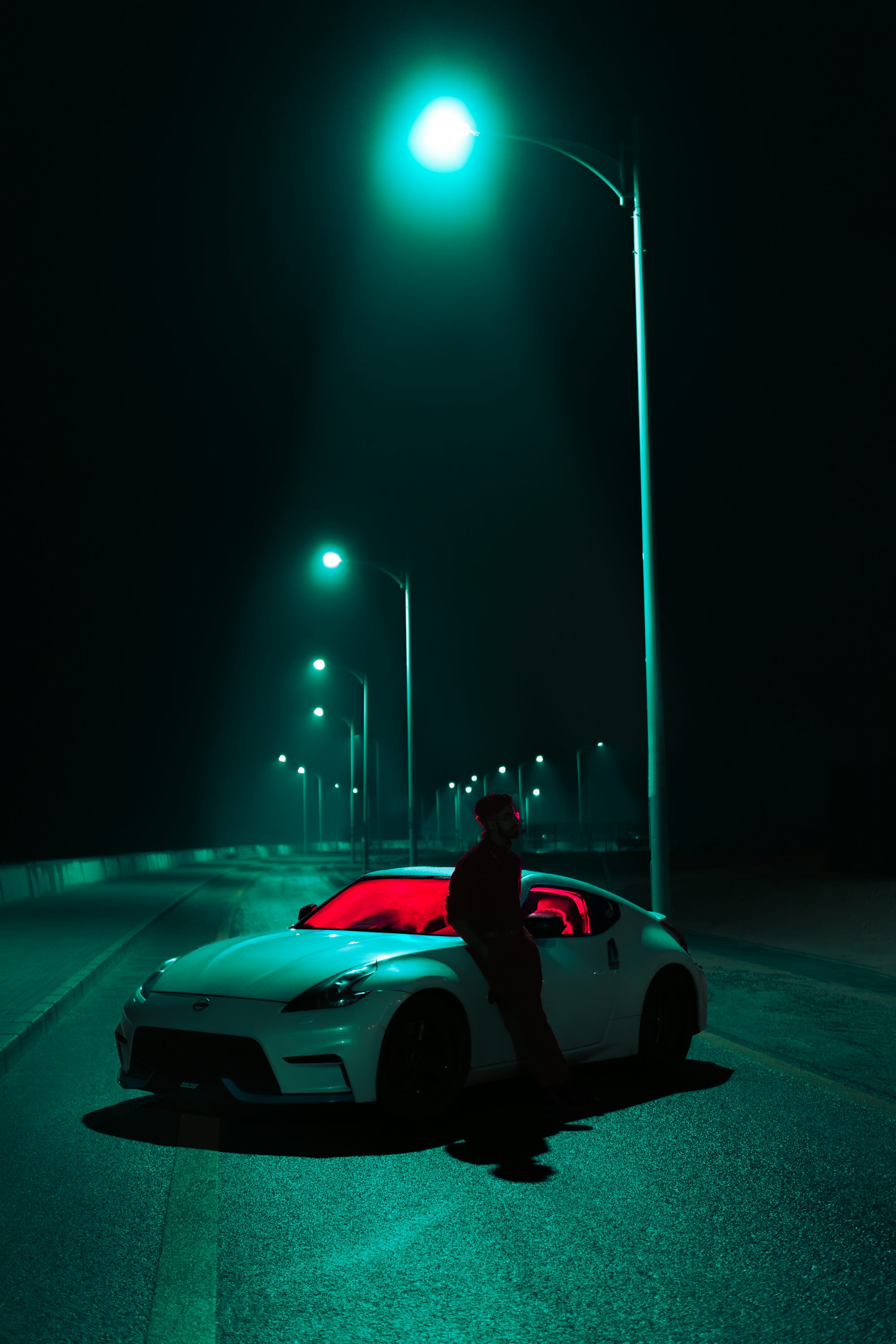 A car parked on the side of the road at night