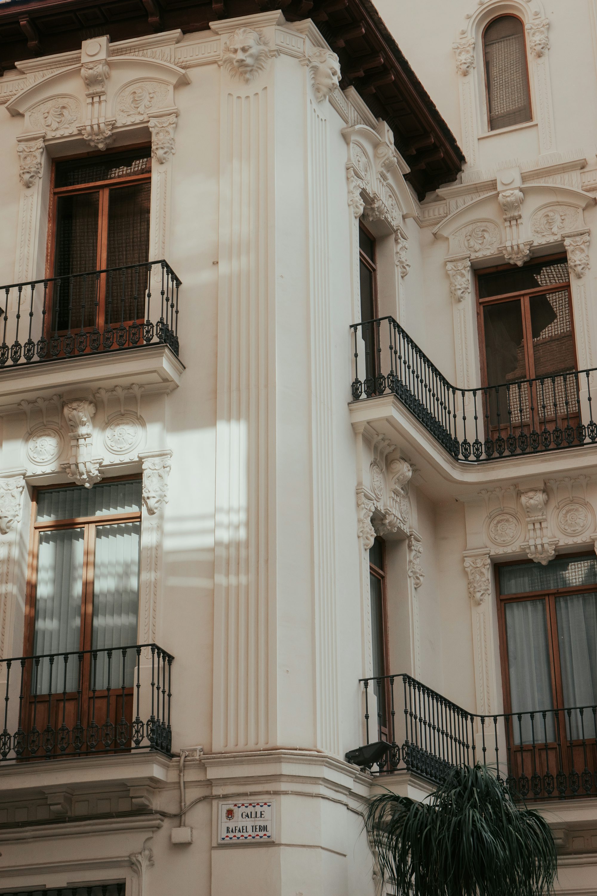 A tall white building with balconies and balconies